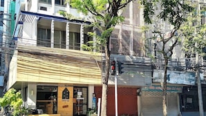 A building with a storefront labeled "FORESTTEL" and a closed shutter to the right. - Foresttel Bkk - Hostel (Bangkok)
