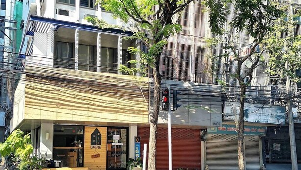 A building with a storefront labeled "FORESTTEL" and a closed shutter to the right. - Foresttel Bkk - Hostel (Bangkok)