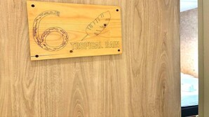 A wooden plaque with the number 6 and the words "TROPICAL RAIN" on a wooden wall. - Foresttel Bkk - Hostel (Bangkok)