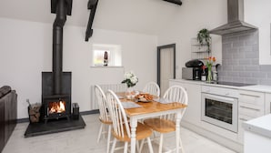 Een moderne keuken met een centraal eiland, witte kasten en een inbouwfornuis.