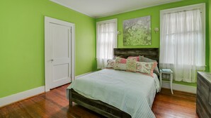 A bedroom with a bed, a nightstand, a dresser, and a door. - Stay just 3 miles from Augusta National during Masters Week! (Augusta)