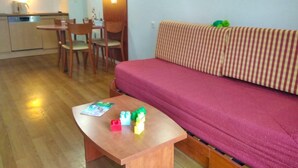 A compact living space with a kitchenette, a dining area, and a sofa.