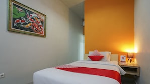 Una habitación de hotel con una cama, una mesita de noche, una lámpara y un cuadro en la pared.