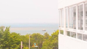 A view of a coastal area with a building featuring large windows. - apartamento bahía fragata  (San Andrés)