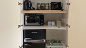 A kitchen with a Bosch microwave, a Bosch toaster, a Montpelier refrigerator, and various kitchen utensils and containers. - The Bruce @ RWY Studio - sleeps 4 guests  in 1 bedroom (Plymouth)