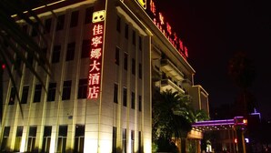 Un hotel con señalización iluminada, varios pisos y un diseño arquitectónico moderno.