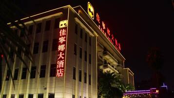 A hotel with illuminated signage, multiple floors, and a modern architectural design.