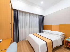 Una habitación de hotel con cama, escritorio y mesita de noche.
