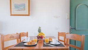A breakfast table with a pineapple, bananas, apples, croissants, and orange juice. - Bluesea Cabo de Banos (Ciutadella de Menorca)