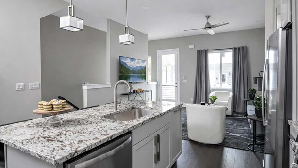 A modern kitchen with a granite countertop, stainless steel appliances, and a ceiling fan. - Nashville Luxe Retreat • Rooftop & Hot Tub (Nashville)