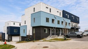 A modern multi-story residential building with a flat roof, a garage, and a driveway. - Nashville Luxe Retreat • Rooftop & Hot Tub (Nashville)