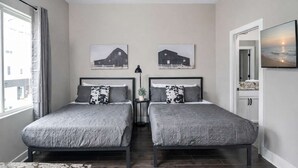 A bedroom with two beds, a ceiling fan, and two barn-themed wall art pieces. - Music City Luxe Stay • Rooftop & Hot Tub (Nashville)