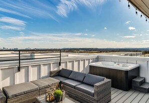 A rooftop terrace with a hot tub, outdoor seating, and a city skyline view. - Two Luxury Homes • Side-by-Side • Sleeps 24 (Nashville)