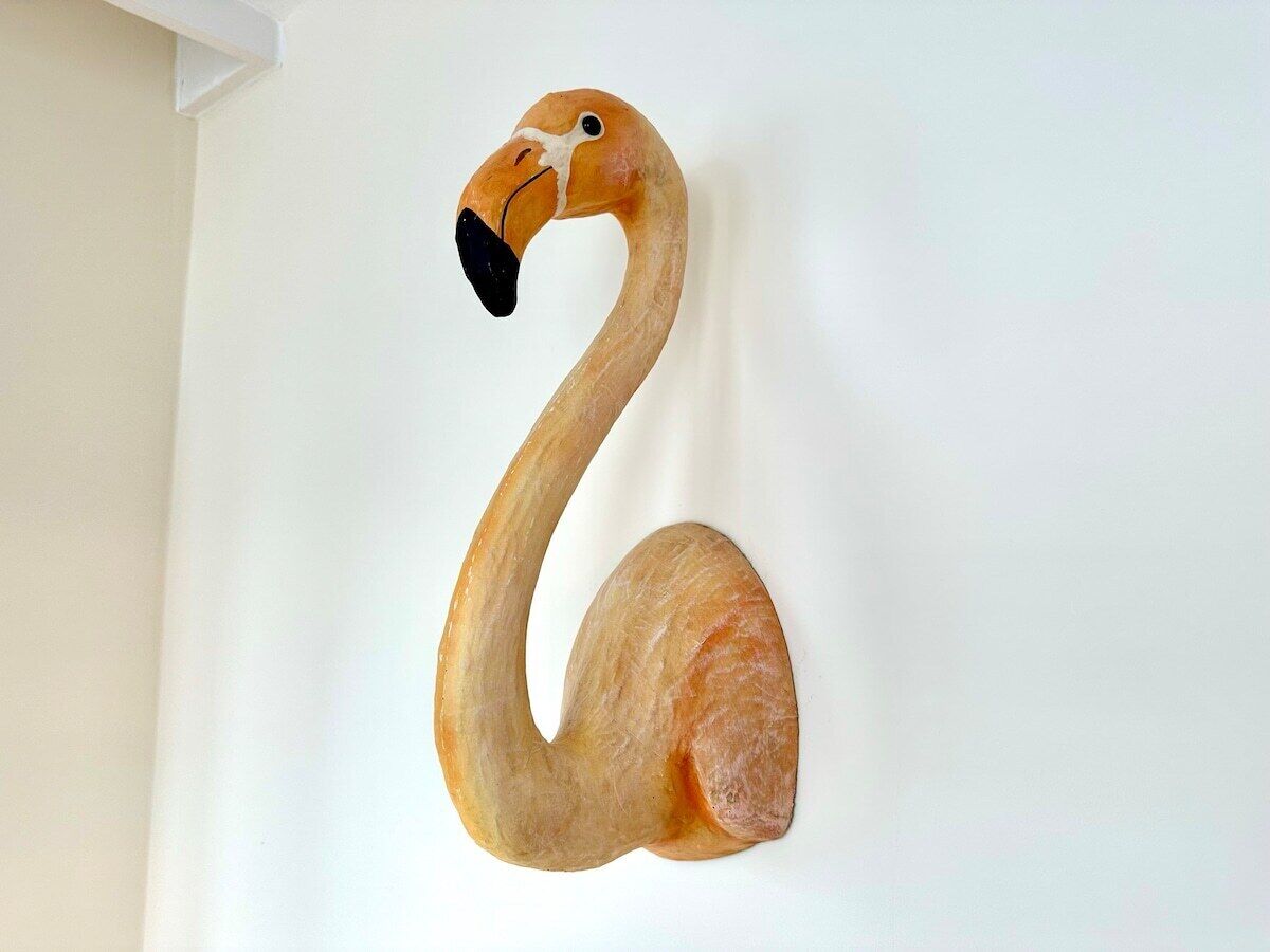 A wooden swan sculpture mounted on a wall.