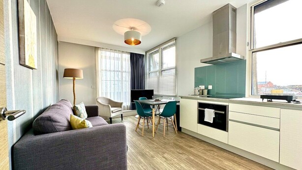 Un apartamento moderno con sala de estar, comedor y cocina.