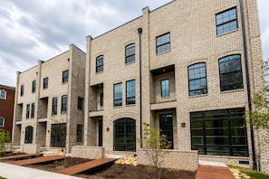 A multi-story brick building with large windows and a flat roof. - 2 New Nashville Homes • Near Vandy & 3 Min to Bars (Nashville)