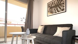 A modern living room with a grey sofa, a small white table, and a decorative vase. - Relax Oasis of the Sea, Santiago del Teide (Puerto Santiago)