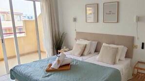 A bedroom with a bed, a bedside table, a nightstand, a window with curtains, and two framed pictures on the wall. - Relax Oasis of the Sea, Santiago del Teide (Puerto Santiago)