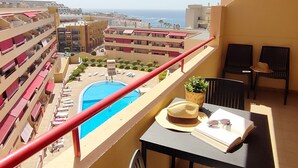 A balcony with a pool, lounge chairs, and a table with a hat and sunglasses. - Relax Oasis of the Sea, Santiago del Teide (Puerto Santiago)