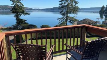 Enjoy a serene lakeside view from this balcony with a clear view of the surrounding hills.