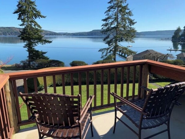 Enjoy a serene lakeside view from this balcony with a clear view of the surrounding hills.