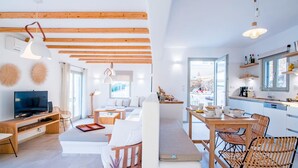 A modern living room with a TV, sofa, and dining area. - Villa Flo by Anamnesia Collection (Naxos)