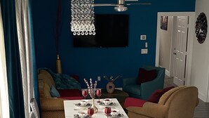 A dining area with a table set for six, a sofa, and a chair.