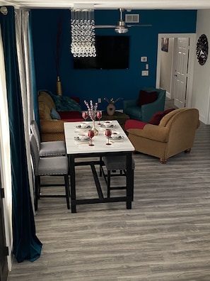 Cozy living space with a dining area, flat-screen TV, and comfortable seating for a gathering.