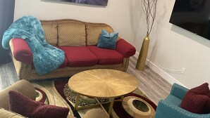 A modern living room with a sofa, a coffee table, and a TV.