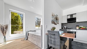 Een modern appartement met een groot raam, een gezellige zithoek en een compacte keuken.