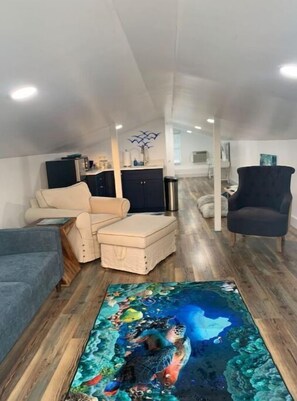 Relax in this stylish living area with a vibrant rug, comfortable seating, and a fully equipped kitchen.