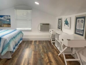Cozy retreat with a comfortable bed, desk, and artwork adorns the walls.