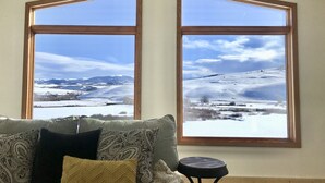 Una habitación con un ventanal que ofrece vistas a un paisaje nevado.
