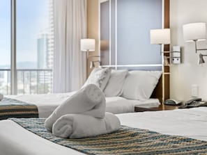 A hotel room with two beds, a view of the city, and a telephone on the nightstand. - Amazing suite with beach views at prime location (Surfers Paradise)