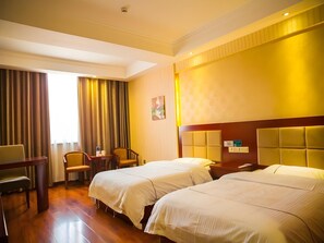 A hotel room with two beds, a desk, chairs, and a window with curtains. - Greentree Inn Jiayuguan Xinhua Nan Road (Jiayuguan)