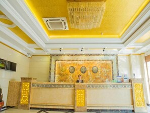 A reception area with a marble counter, a chandelier, and a wall clock. - Greentree Inn Jiayuguan Xinhua Nan Road (Jiayuguan)