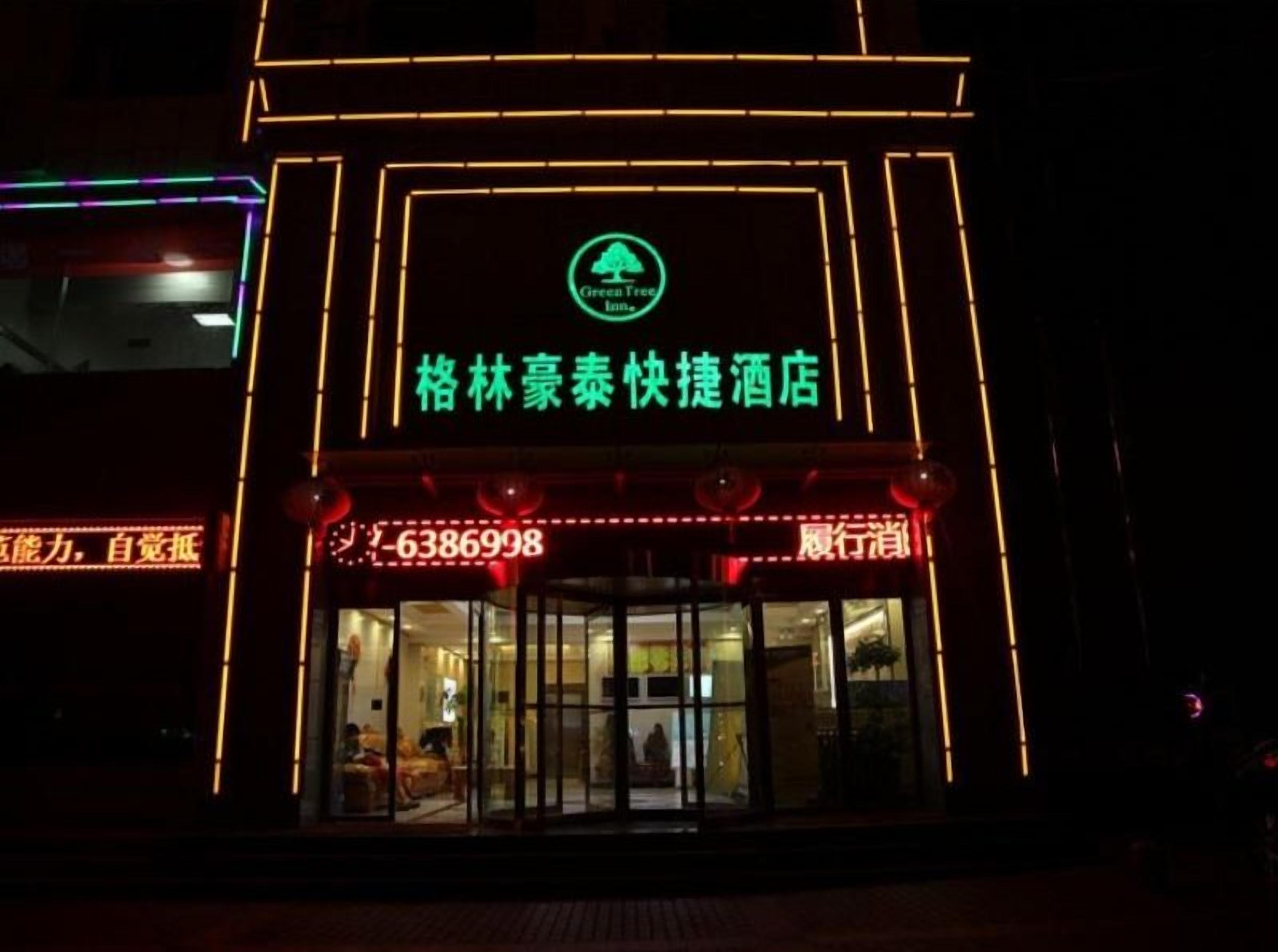L’entrée d’un hôtel, avec une enseigne lumineuse et un comptoir d’accueil.