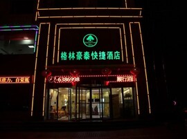 Entrada de hotel con señalización iluminada y un mostrador de recepción.