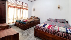 A bedroom with two wooden beds, a window with curtains, a wooden wardrobe, and a tiled floor. - Narendra Homestay by Zuzu (Sleman)