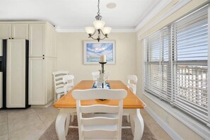 Enjoy meals in this dining area with a table, chairs, and a chandelier.
