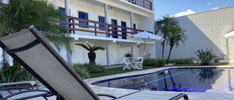 Alberca al aire libre y camastros