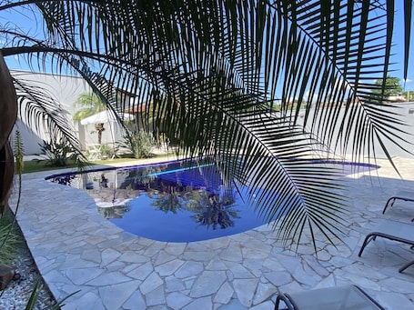 Una piscina al aire libre, sillones reclinables de piscina