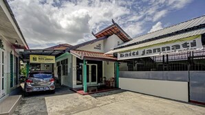 A building with a sign reading "baiti jannati" and a covered entrance. - OYO 3724 Penginapan Baiti Jannati Syariah (Banjarbaru)