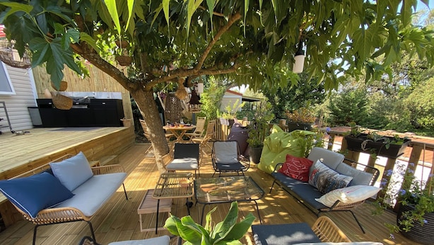 A wooden deck with wicker furniture, a table, and a potted plant. - Rental St tropez Gassin luxury bungalow 6pers (Gassin)