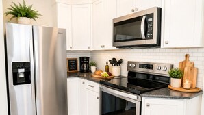 Una cocina moderna con electrodomésticos de acero inoxidable, cafetera y microondas.