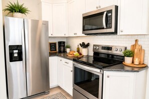 A modern kitchen with stainless steel appliances, a coffee maker, and a microwave.
