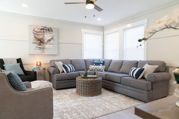Spacious and inviting living area with a large sectional sofa and cozy seating. Designed for families to gather, relax, and enjoy time together in a comfortable, open space.