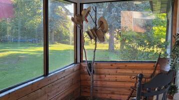 Una cabaña de madera con amplios ventanales, un interior rústico y vistas a un paisaje verde.