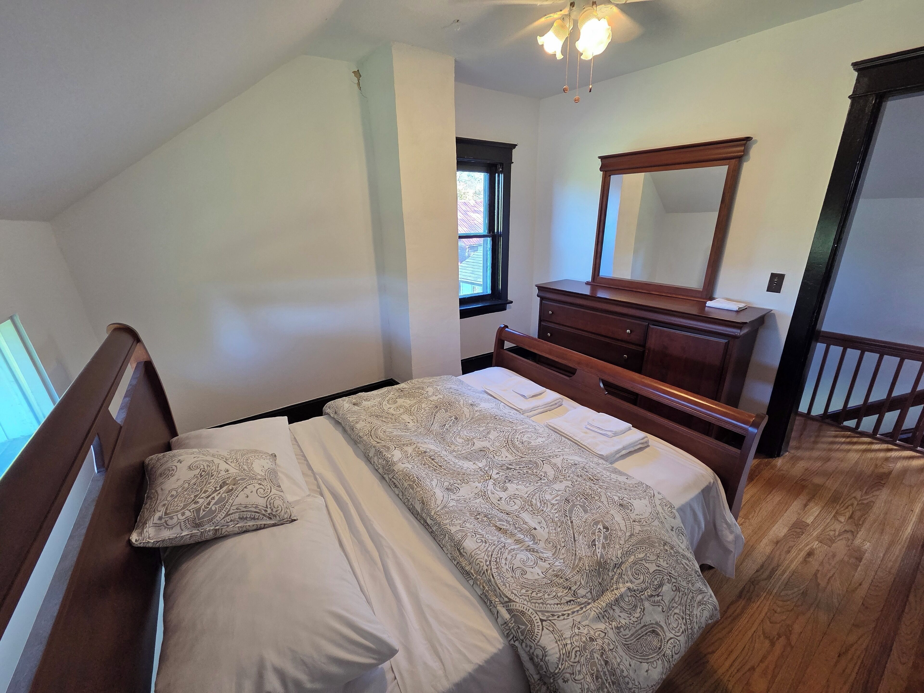 Een slaapkamer met een bed, een kaptafel en een spiegel.