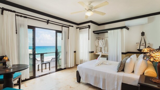 A hotel room with a bed, a desk, a chair, and a view of the ocean. - Casa Sirena 8 Bedroom in Centro Villa with Pool, Walk Everywhere, Group Ready (Isla Mujeres)